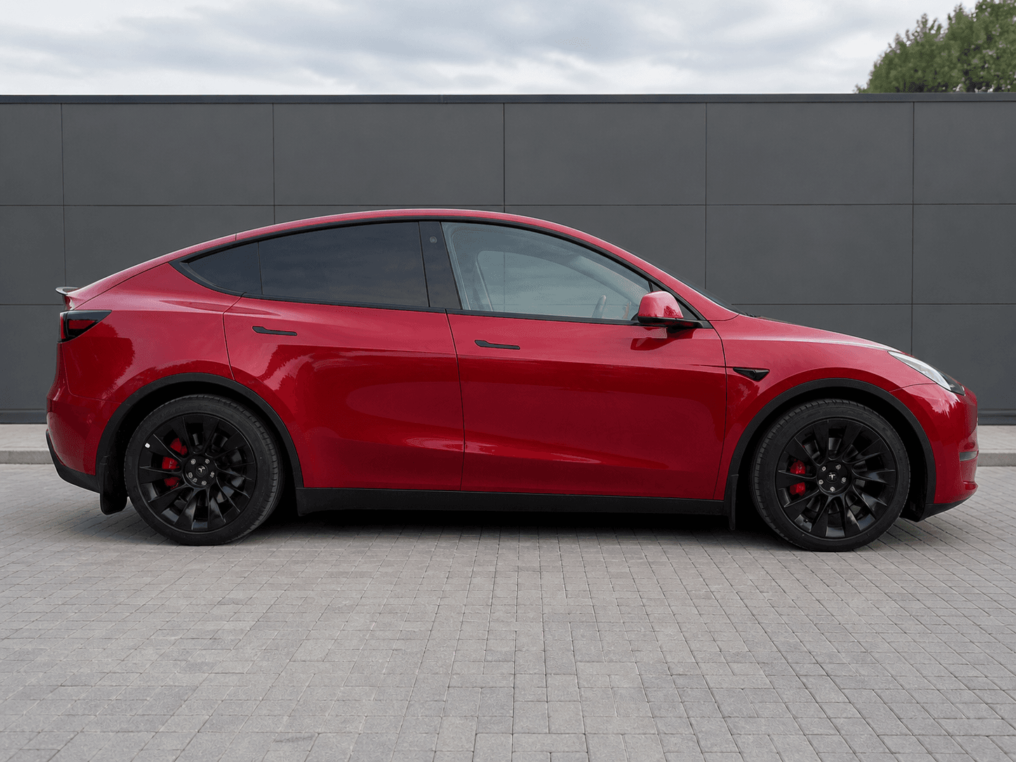 Красная Tesla Model Y Performance 2023 после восстановления, презентационный вид сбоку